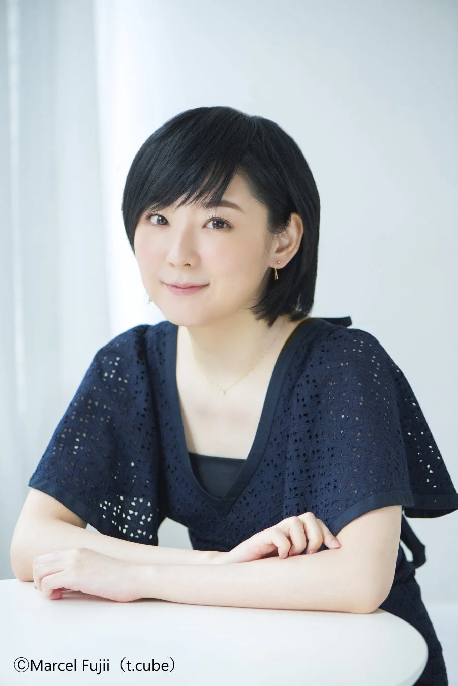 紺色のレースのトップスを着たショートヘアの女性