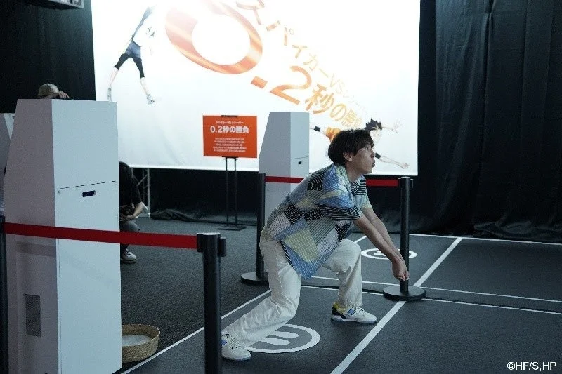 男性がアニメ「ハイキュー!!」をテーマにしたイベントで、バレーボールのレシーブのような姿勢をとる