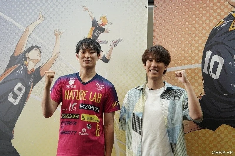 バレーボールアニメ「ハイキュー!!」のキャラクターを背景に、笑顔でガッツポーズをする柳田選手と須貝さん