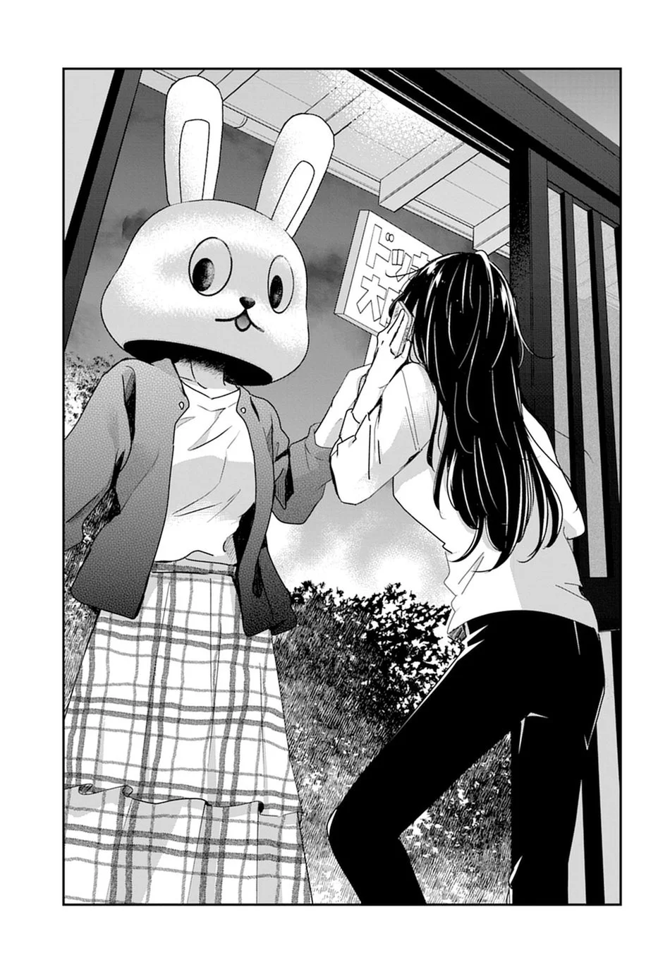 うさぎの着ぐるみを着た人物と、何かを耳に当てている少女が向かい合っているモノクロのマンガの一コマ