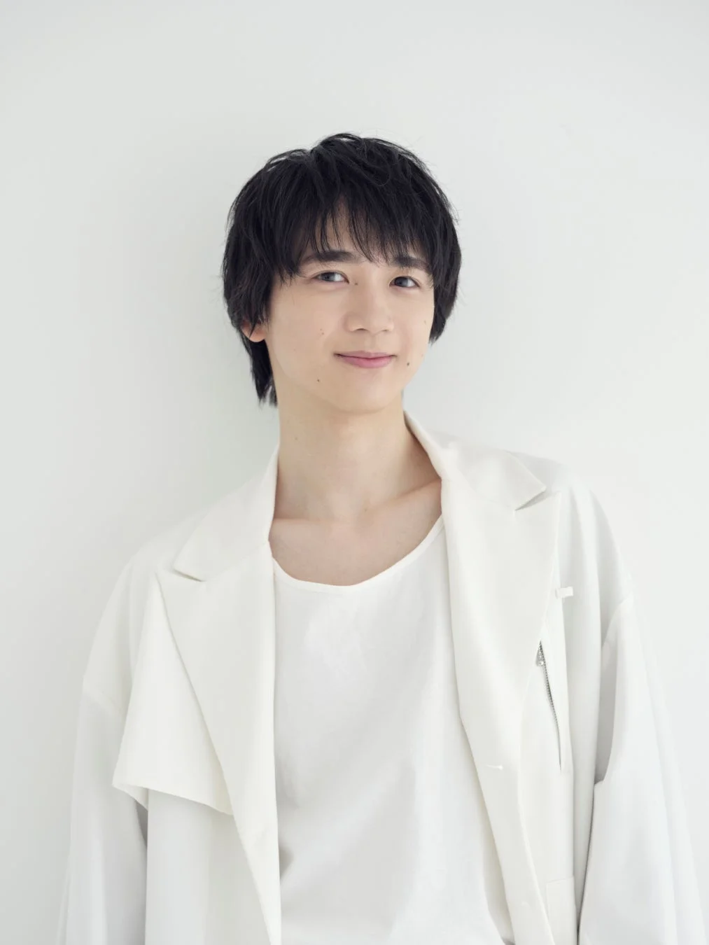 白いジャケットとインナーを着用した戸谷菊之介さんのポートレート