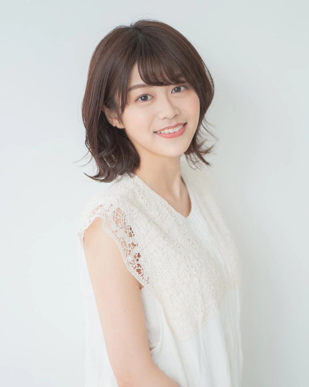 白いレースのトップスを着た田中貴子さんのポートレート